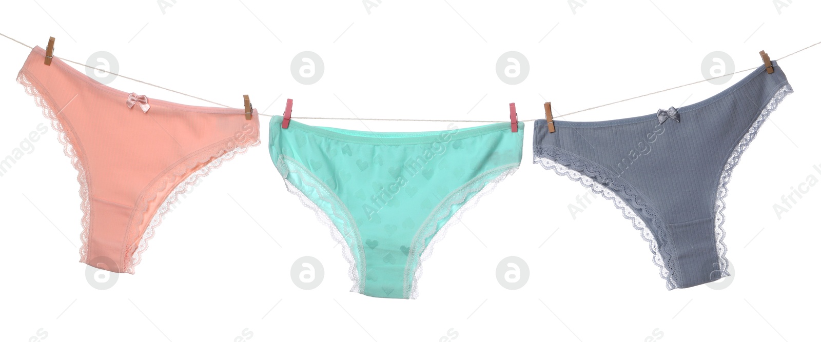 Beautiful panties on clothes line against white background Photo of Beautiful panties on clothes line against white background