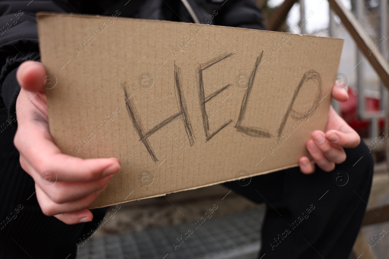 Homeless man holding sign with word Help outdoors, closeup Photo of Homeless man holding sign with word Help outdoors, closeup