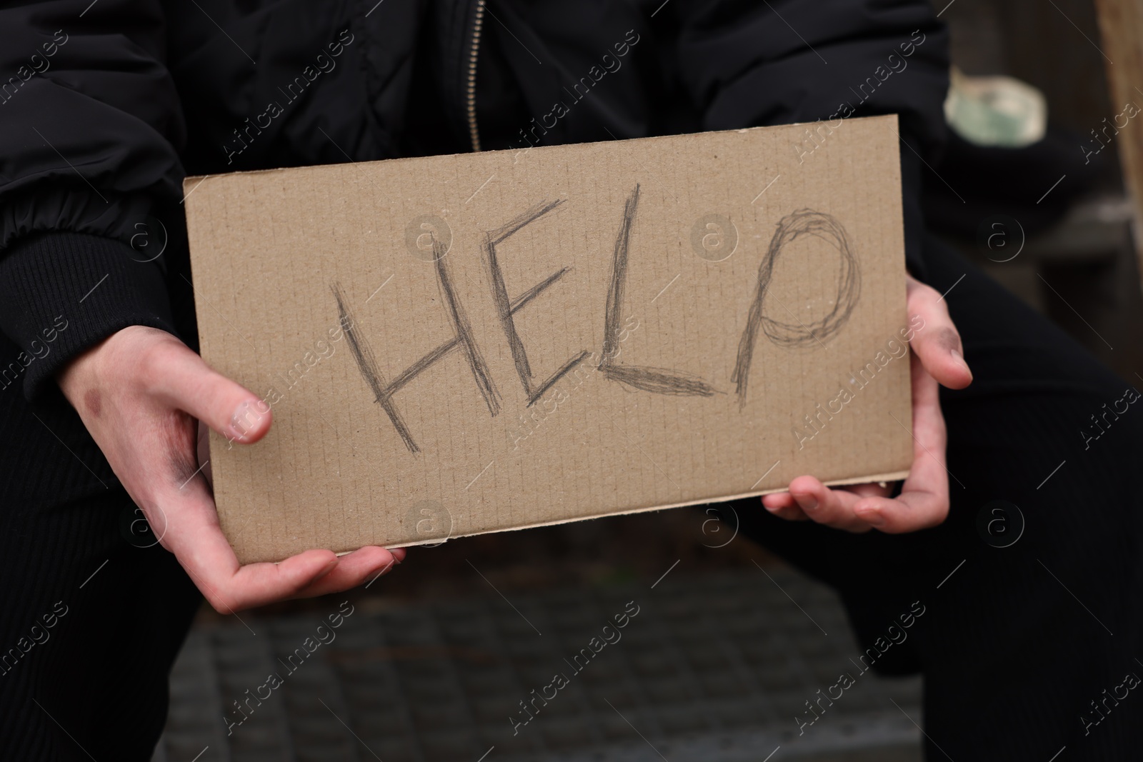 Homeless man holding sign with word Help outdoors, closeup Photo of Homeless man holding sign with word Help outdoors, closeup