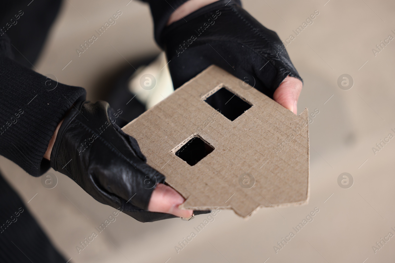 Homeless man with carton house figure outdoors, closeup Photo of Homeless man with carton house figure outdoors, closeup