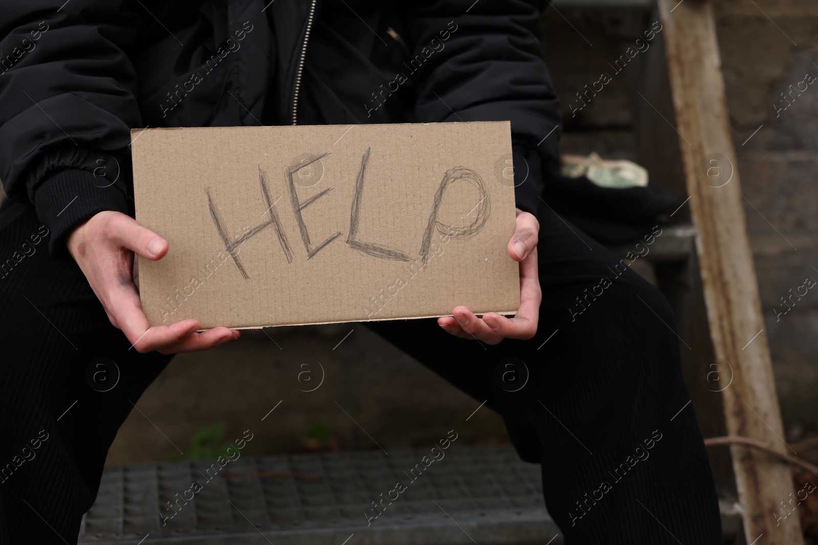 Homeless man holding sign with word Help outdoors, closeup Photo of Homeless man holding sign with word Help outdoors, closeup