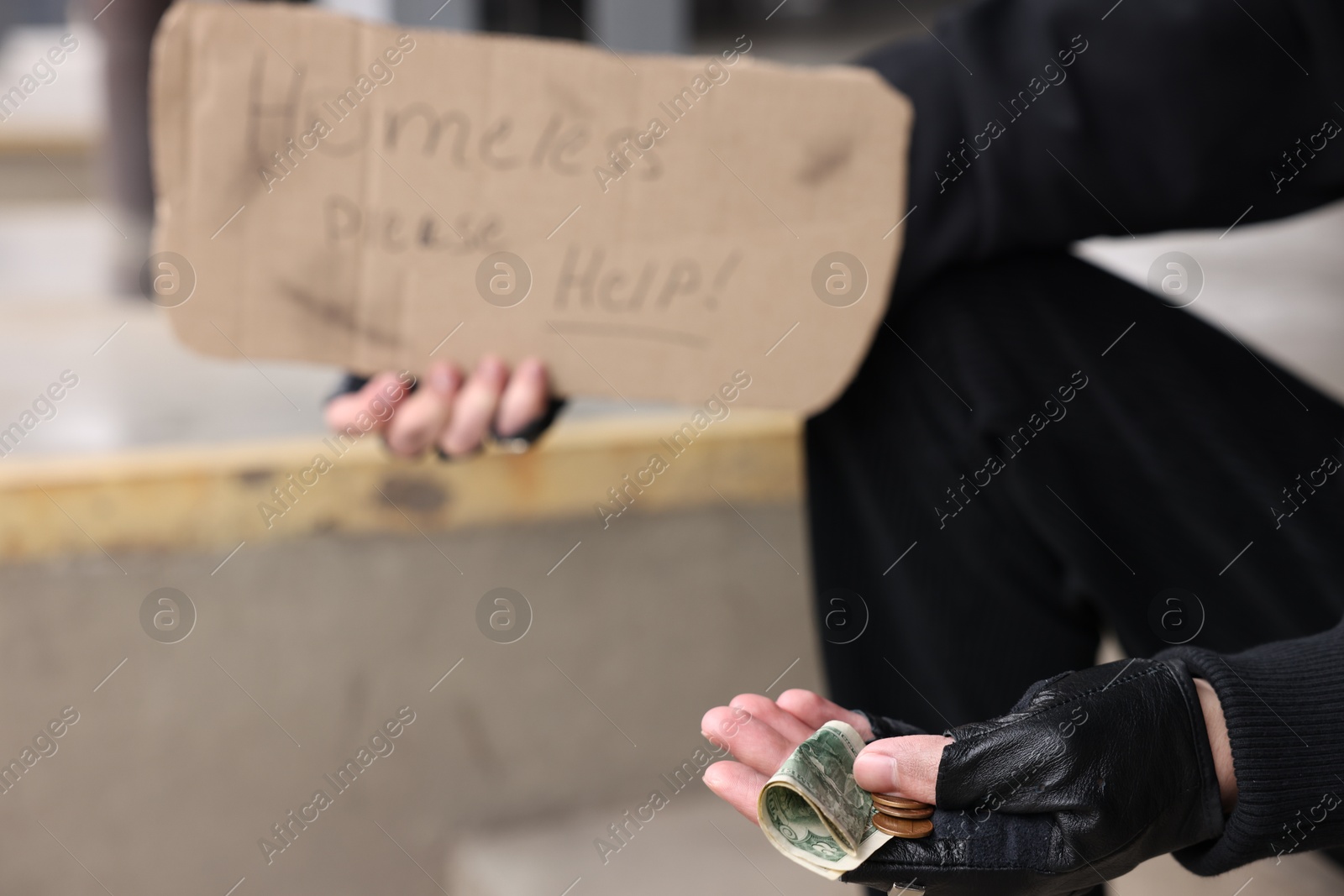 Homeless man with sign and money outdoors, selective focus Photo of Homeless man with sign and money outdoors, selective focus