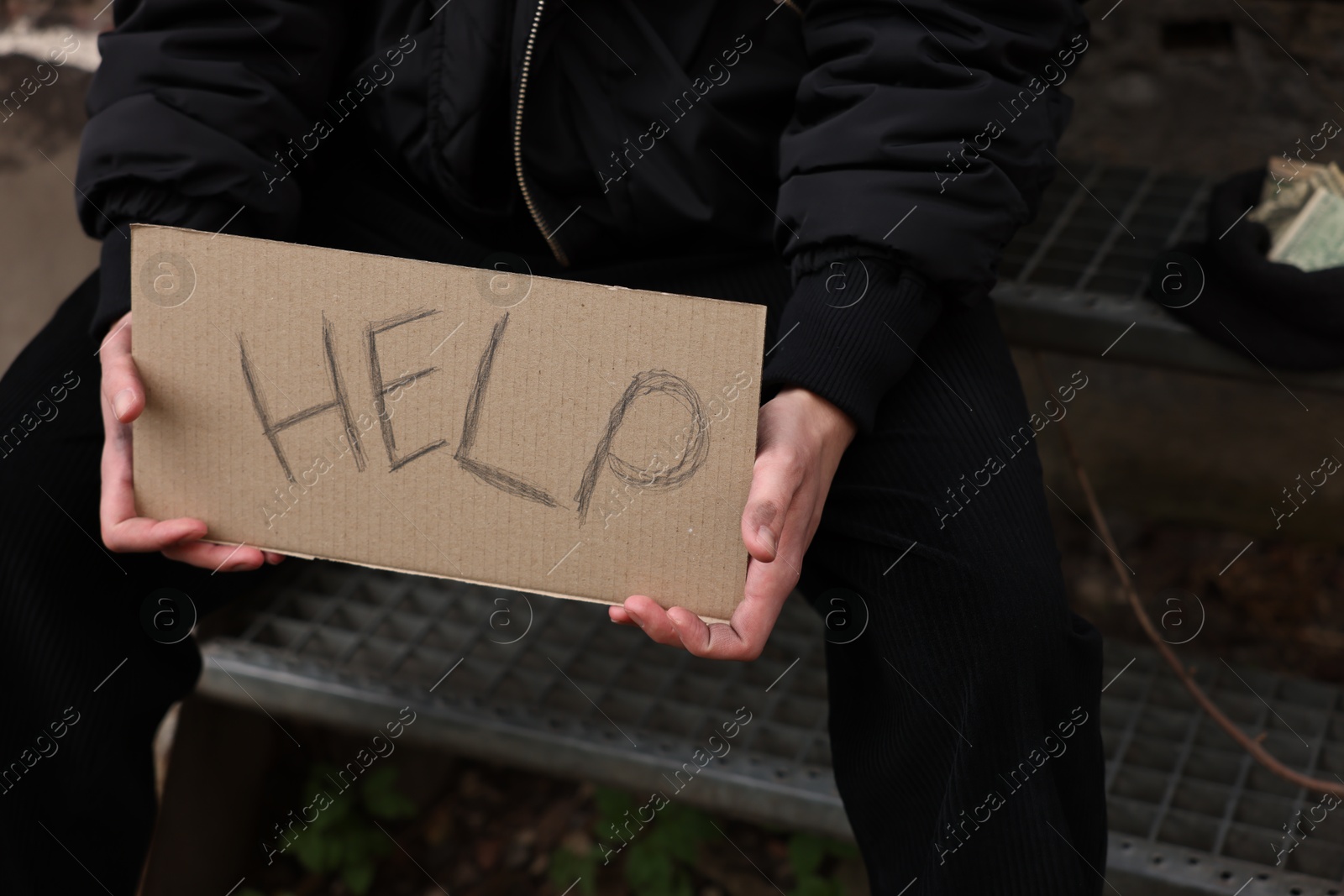 Homeless man holding sign with word Help outdoors, closeup Photo of Homeless man holding sign with word Help outdoors, closeup