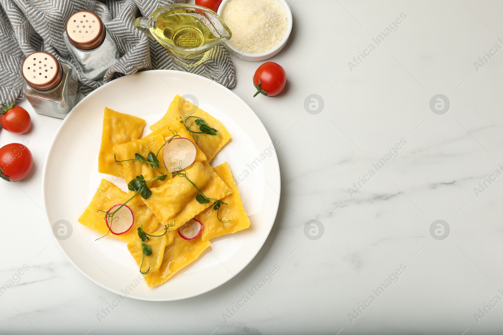 Delicious ravioli with microgreens, radish and other products on light marble table, flat lay. Space for text Photo of Delicious ravioli with microgreens, radish and other products on light marble table, flat lay. Space for text
