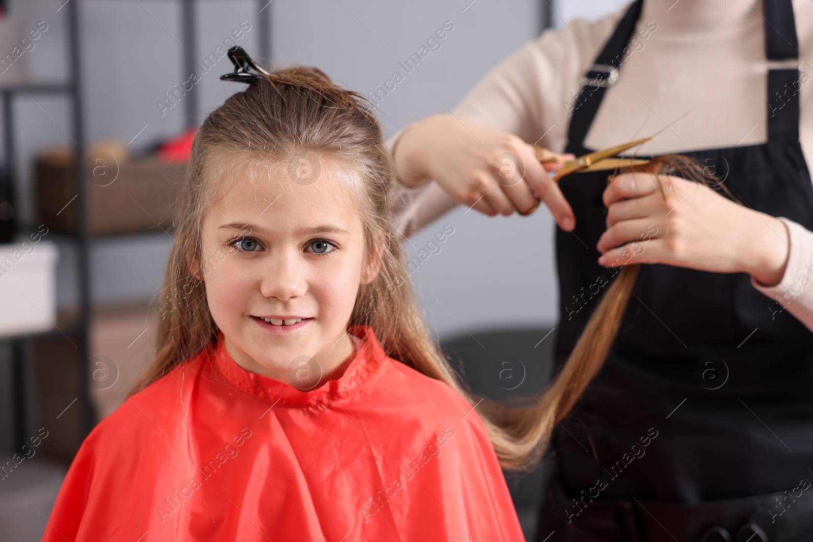 Cute girl getting haircut in beauty salon Photo of Cute girl getting haircut in beauty salon
