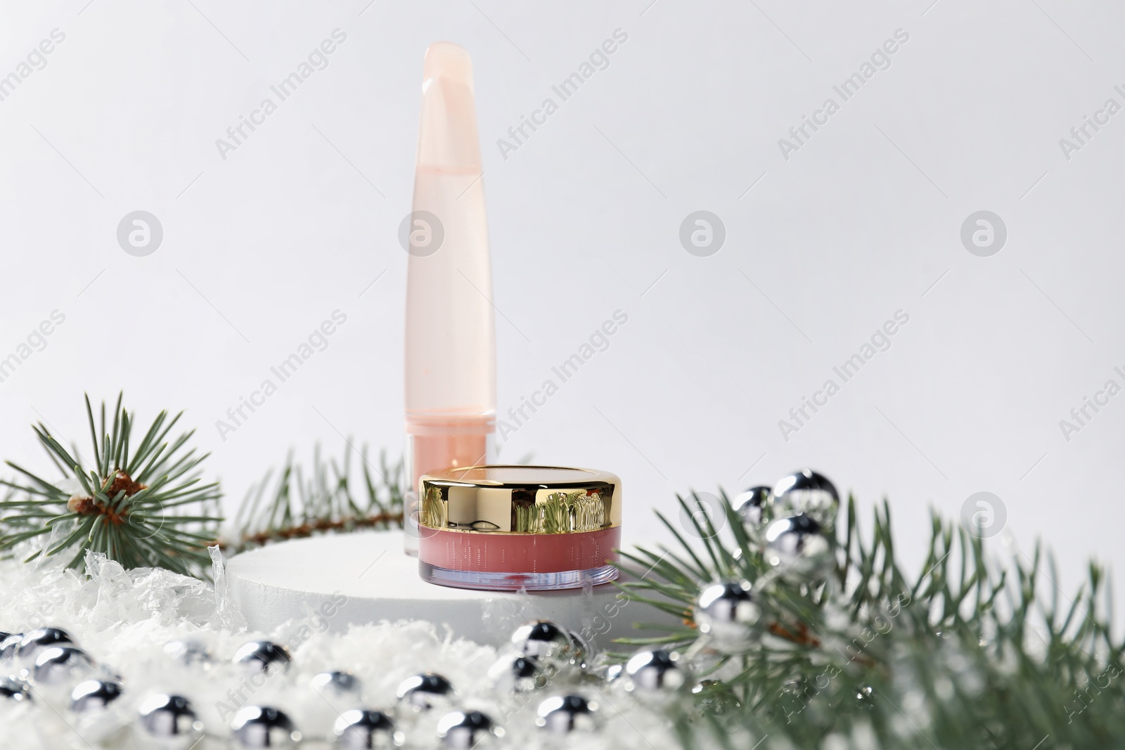 Moisturizing lip balms, Christmas decor and fir tree branches on artificial snow against white background, closeup. Winter care Photo of Moisturizing lip balms, Christmas decor and fir tree branches on artificial snow against white background, closeup. Winter care
