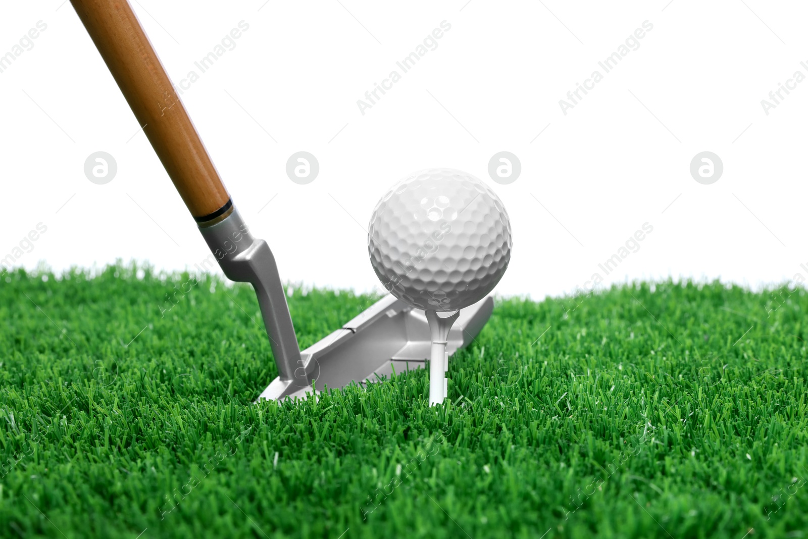 Photo of Golf ball, tee, club and green grass against white background