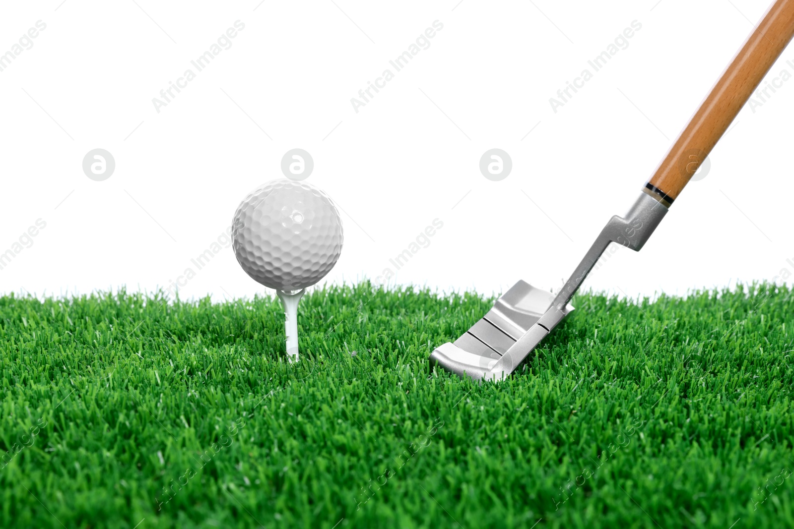 Golf ball, tee, club and green grass against white background Photo of Golf ball, tee, club and green grass against white background