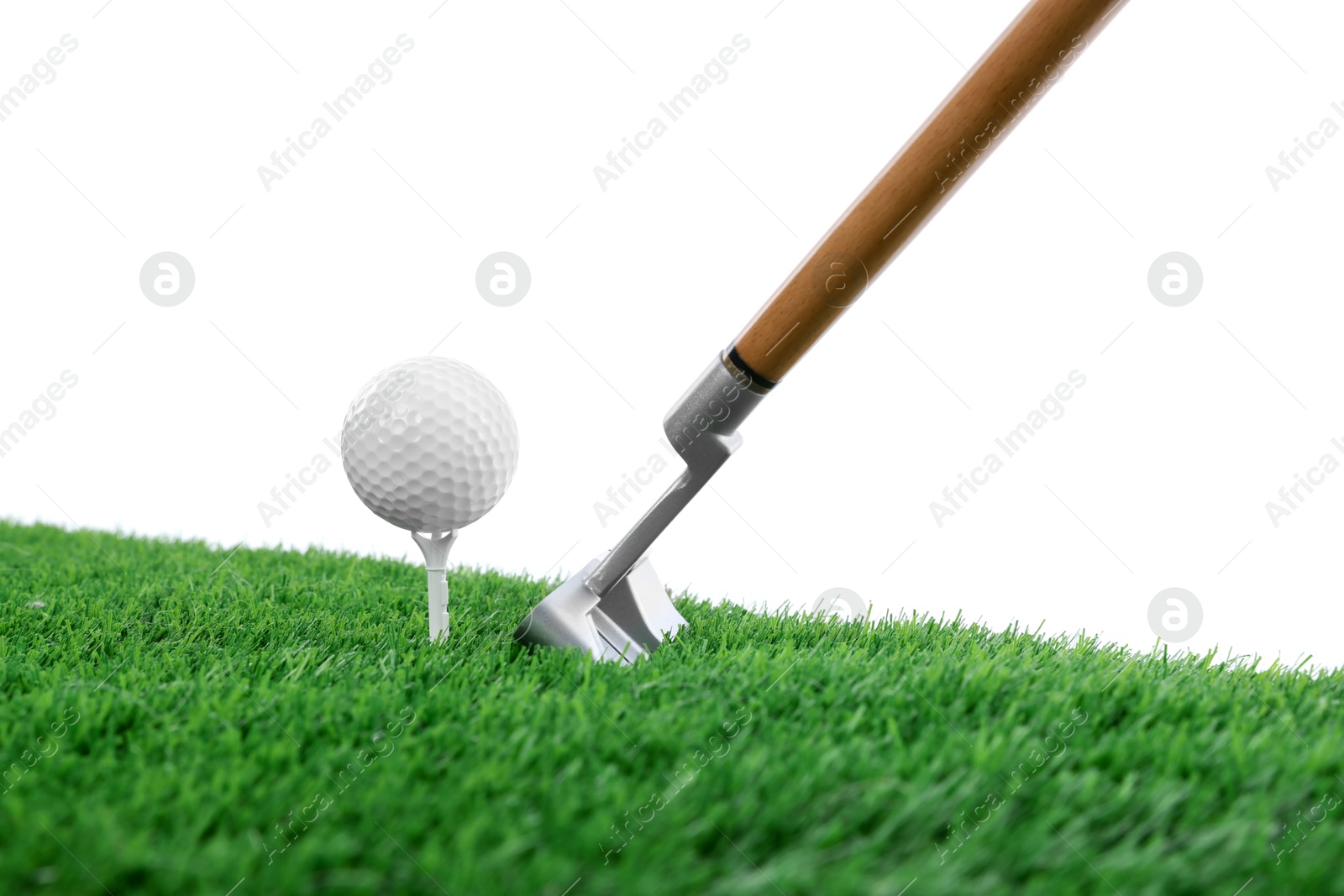 Golf ball, tee, club and green grass against white background Photo of Golf ball, tee, club and green grass against white background