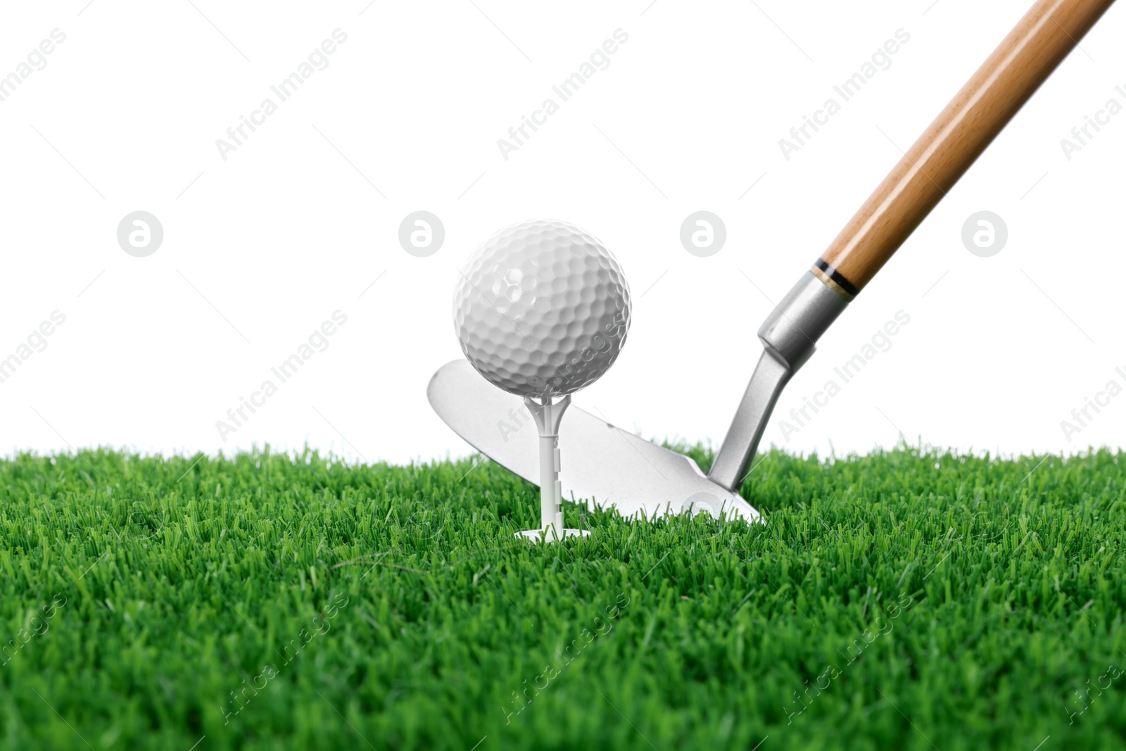 Photo of Golf ball, tee, club and green grass against white background