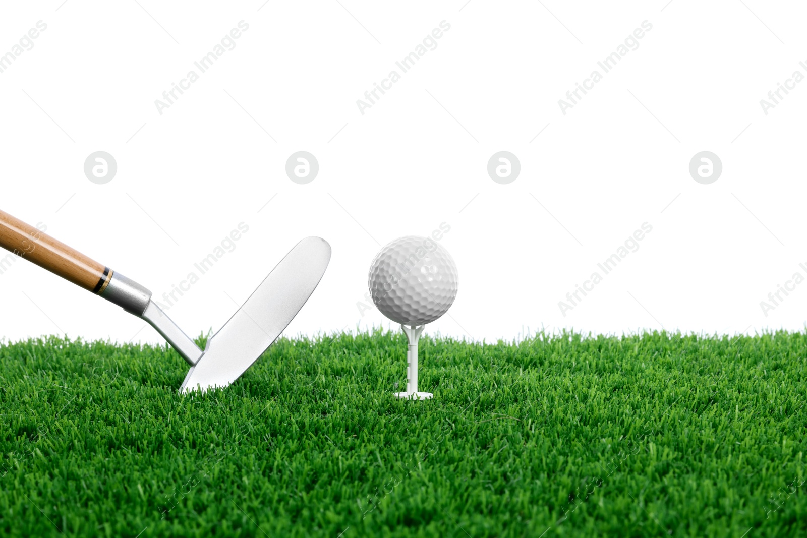 Golf ball, tee, club and green grass against white background Photo of Golf ball, tee, club and green grass against white background