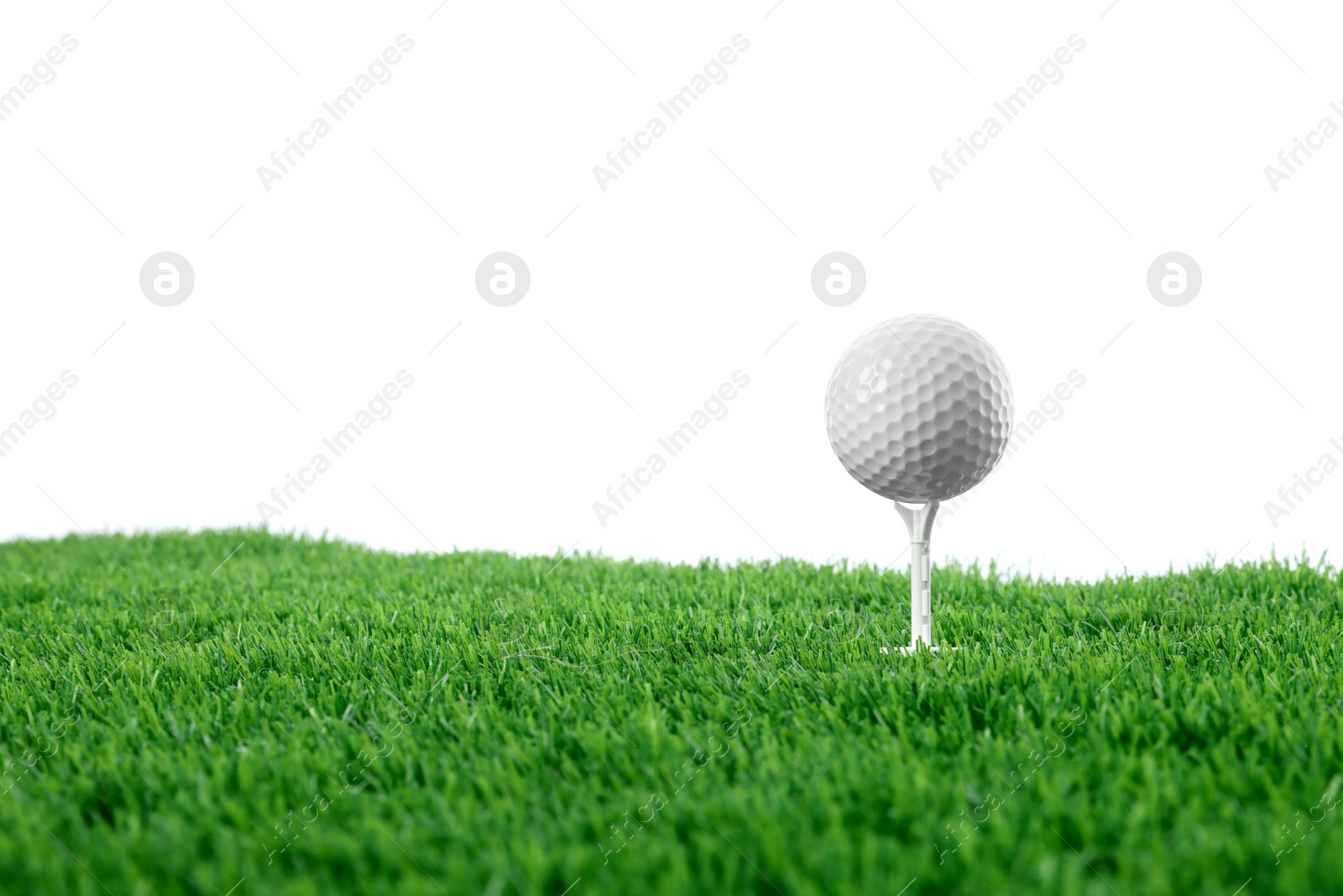 Golf ball, tee and green grass against white background Photo of Golf ball, tee and green grass against white background
