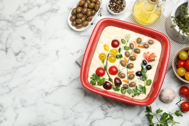 Photo of Raw focaccia with vegetables, olives and spices on white marble table, flat lay. Space for text