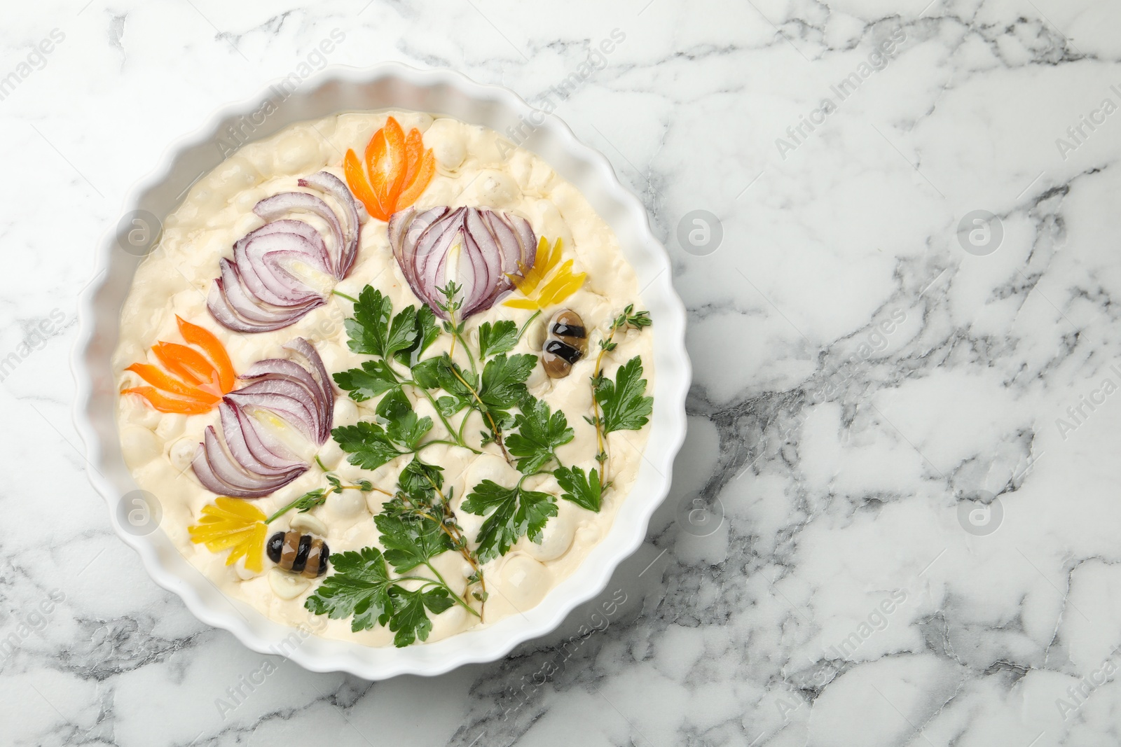 Raw focaccia with vegetables and olives in baking dish on white marble table, top view. Space for text Photo of Raw focaccia with vegetables and olives in baking dish on white marble table, top view. Space for text