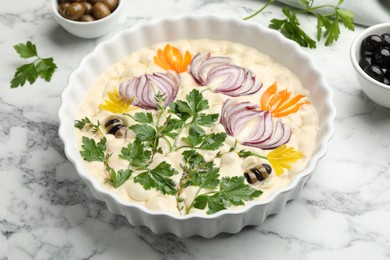 Photo of Raw focaccia with vegetables and olives on white marble table, closeup