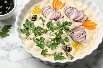 Photo of Raw focaccia with vegetables and olives on white marble table, above view