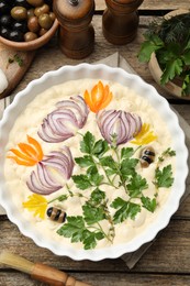 Photo of Raw focaccia with vegetables, olives, spices and brush on wooden table, flat lay
