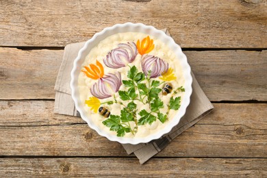 Photo of Raw focaccia with vegetables and olives in baking dish on wooden table, top view