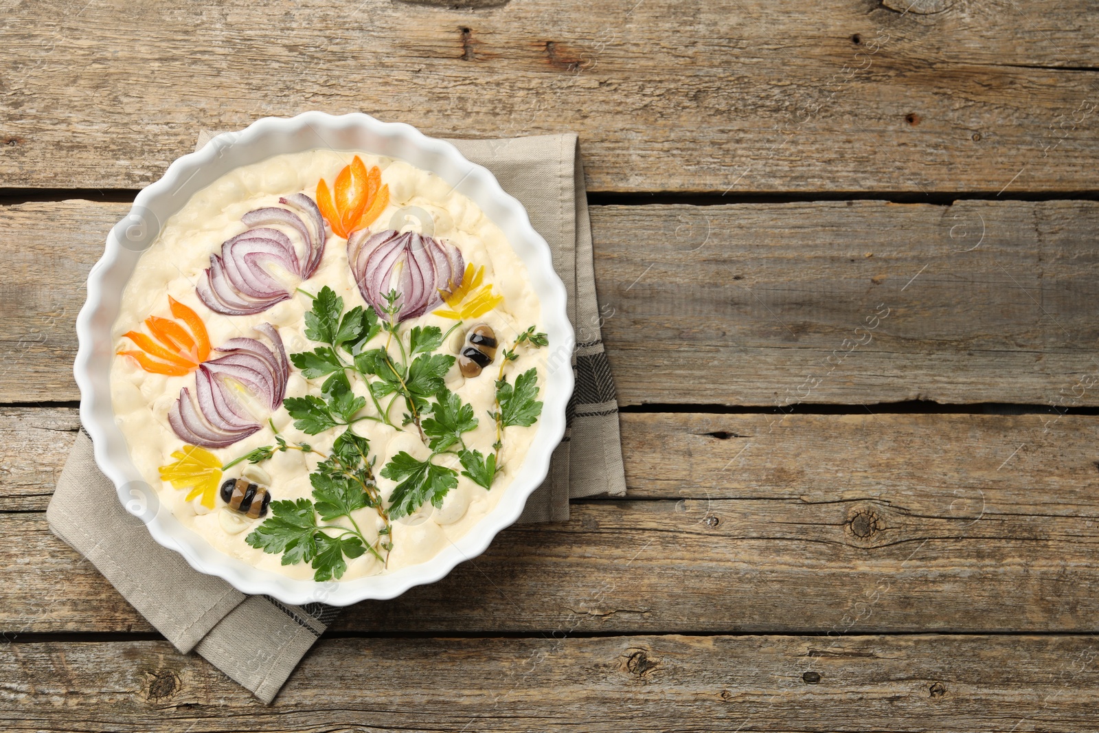 Raw focaccia with vegetables and olives in baking dish on wooden table, top view. Space for text Photo of Raw focaccia with vegetables and olives in baking dish on wooden table, top view. Space for text