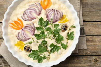 Photo of Raw focaccia with vegetables and olives in baking dish on wooden table, top view