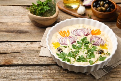 Photo of Raw focaccia with vegetables, olives and spices on wooden table, closeup. Space for text