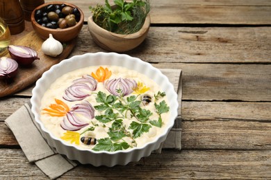 Photo of Raw focaccia with vegetables, olives and spices on wooden table, closeup. Space for text
