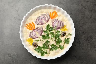 Photo of Raw focaccia with vegetables and olives in baking dish on grey table, top view