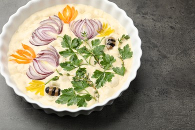 Photo of Raw focaccia with vegetables and olives in baking dish on grey table, above view. Space for text