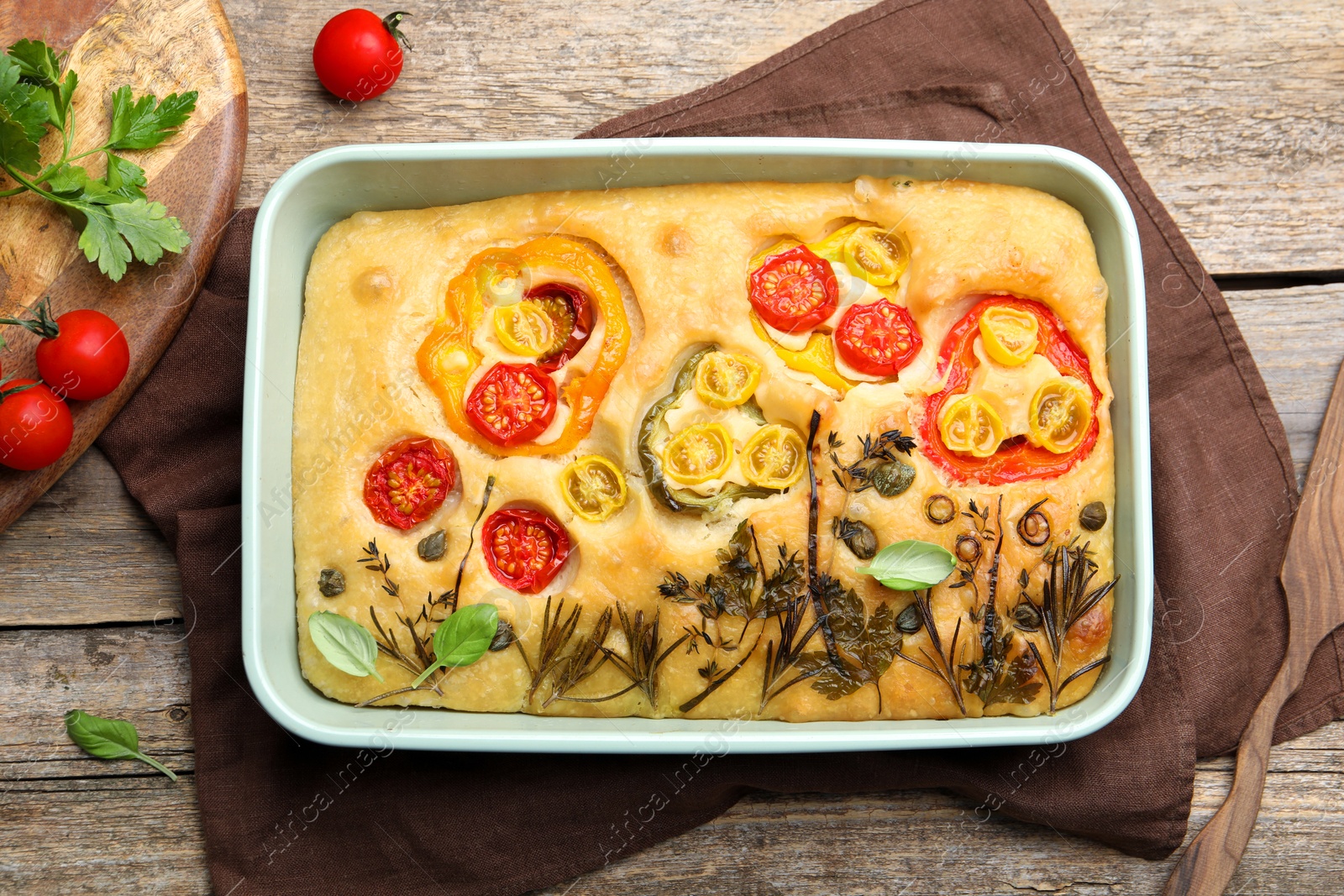 Delicious focaccia with flowers made of vegetables on wooden table, top view Photo of Delicious focaccia with flowers made of vegetables on wooden table, top view