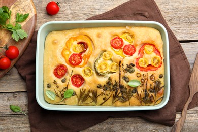 Photo of Delicious focaccia with flowers made of vegetables on wooden table, top view