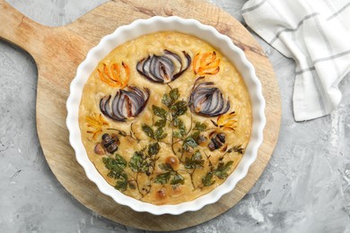 Photo of Delicious focaccia with flowers made of vegetables on grey textured table, top view