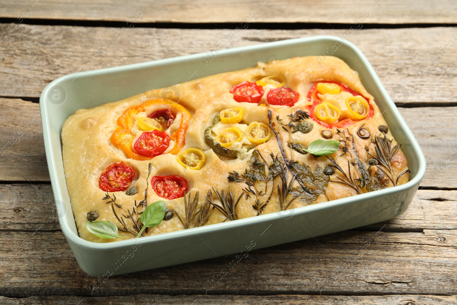 Delicious focaccia with flowers made of vegetables on wooden table, closeup Photo of Delicious focaccia with flowers made of vegetables on wooden table, closeup