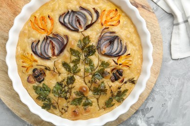 Photo of Delicious focaccia with flowers made of vegetables on grey textured table, top view