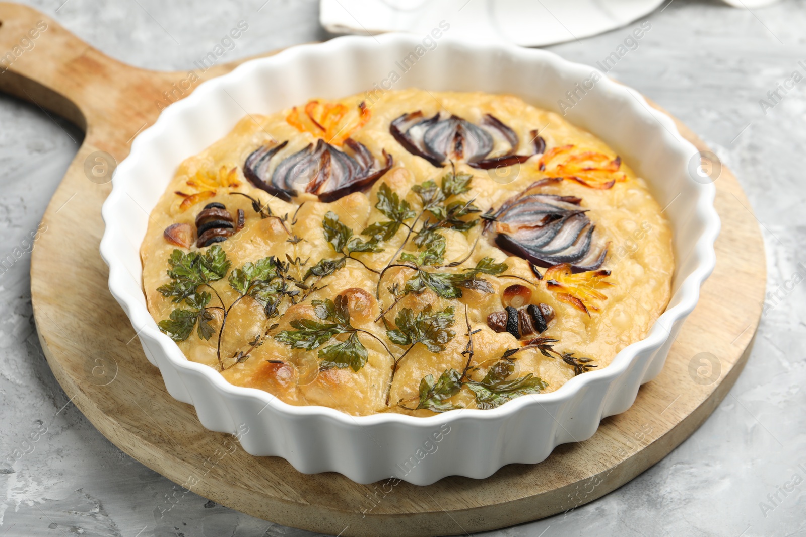 Delicious focaccia with flowers made of vegetables on grey textured table, closeup Photo of Delicious focaccia with flowers made of vegetables on grey textured table, closeup