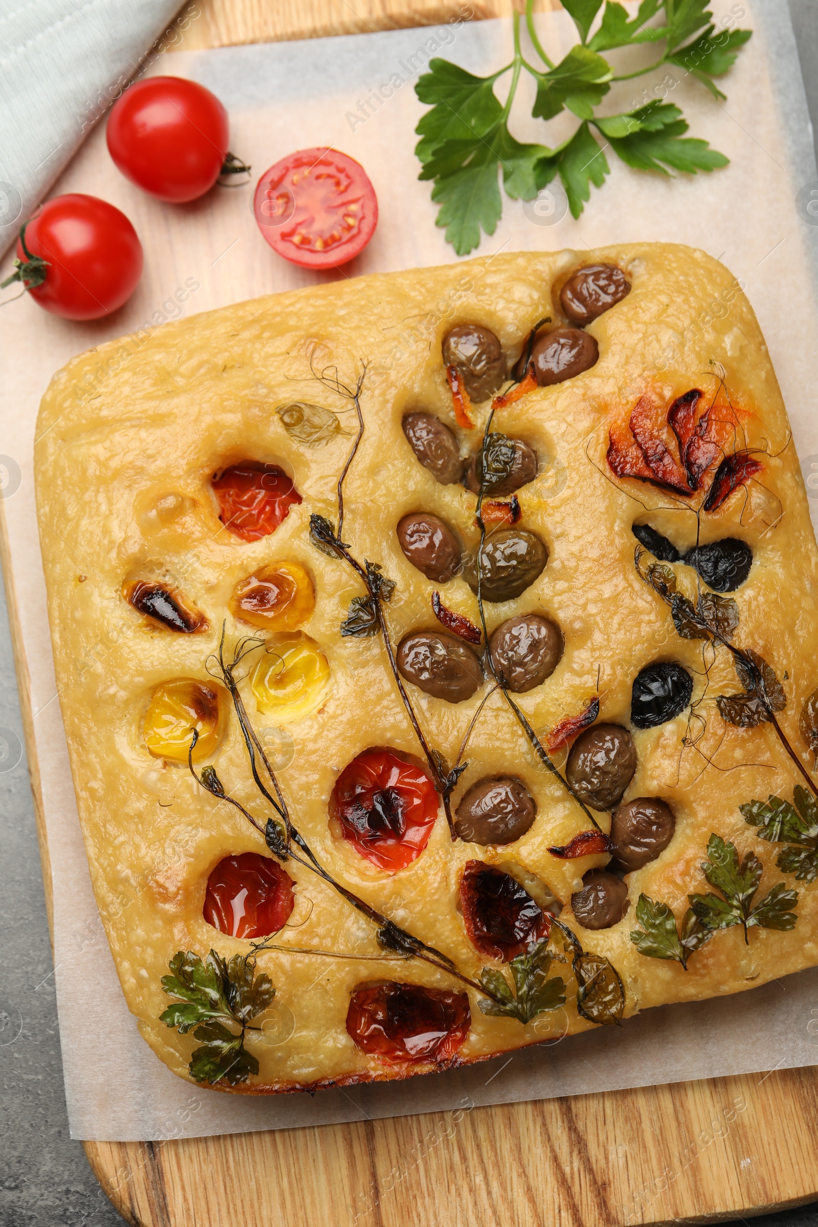 Delicious focaccia with flowers made of vegetables on grey table, top view Photo of Delicious focaccia with flowers made of vegetables on grey table, top view