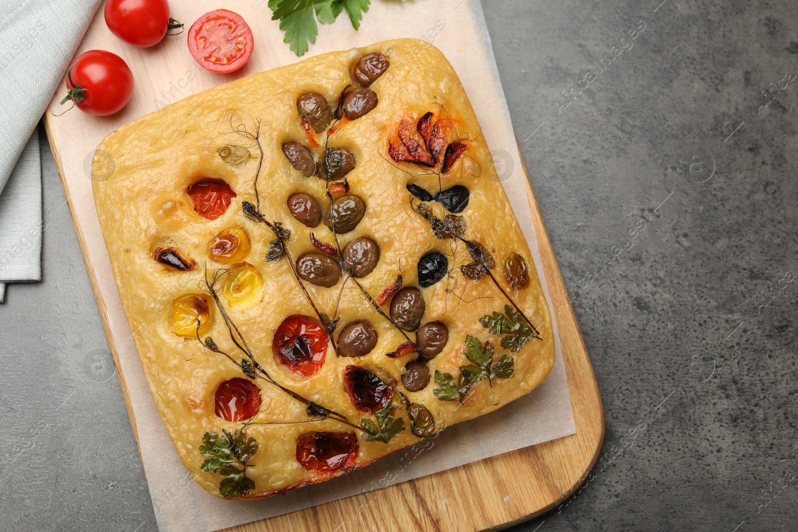Delicious focaccia with flowers made of vegetables on grey table, top view Photo of Delicious focaccia with flowers made of vegetables on grey table, top view