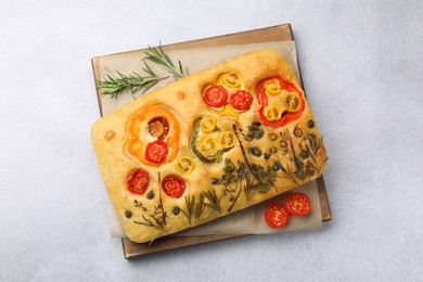 Photo of Delicious focaccia with flowers made of vegetables on light grey table, top view