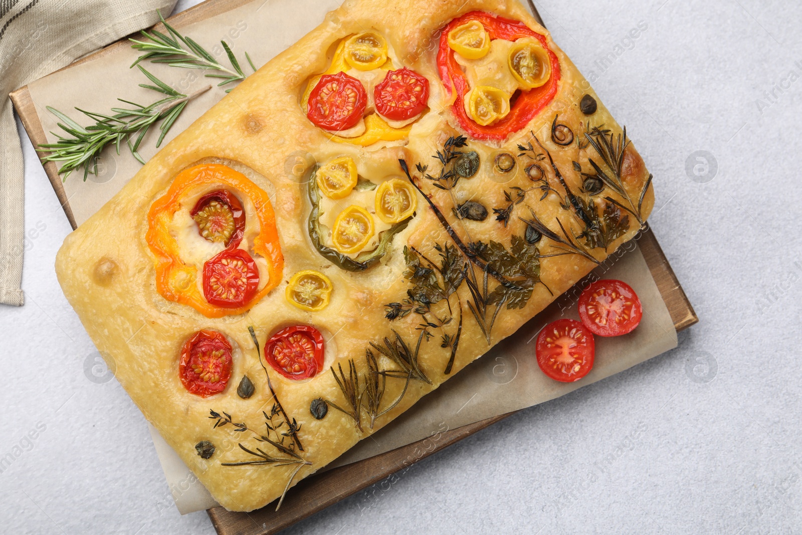 Delicious focaccia with flowers made of vegetables on light grey table, top view Photo of Delicious focaccia with flowers made of vegetables on light grey table, top view