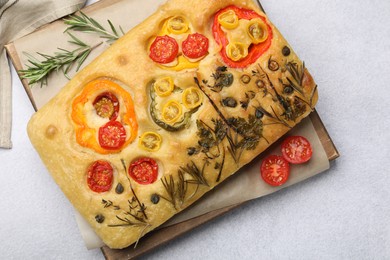 Photo of Delicious focaccia with flowers made of vegetables on light grey table, top view