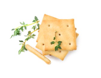 Photo of Tasty salty crackers with thyme isolated on white, top view