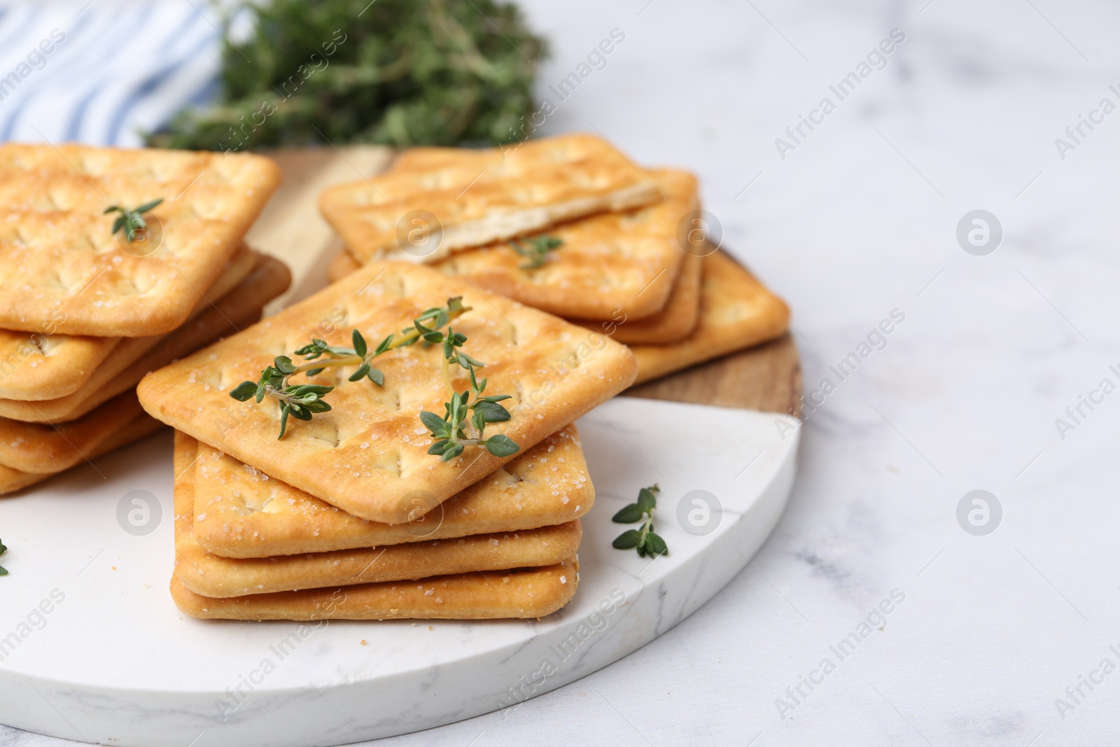 Tasty salty crackers with thyme on white marble table, closeup Photo of Tasty salty crackers with thyme on white marble table, closeup