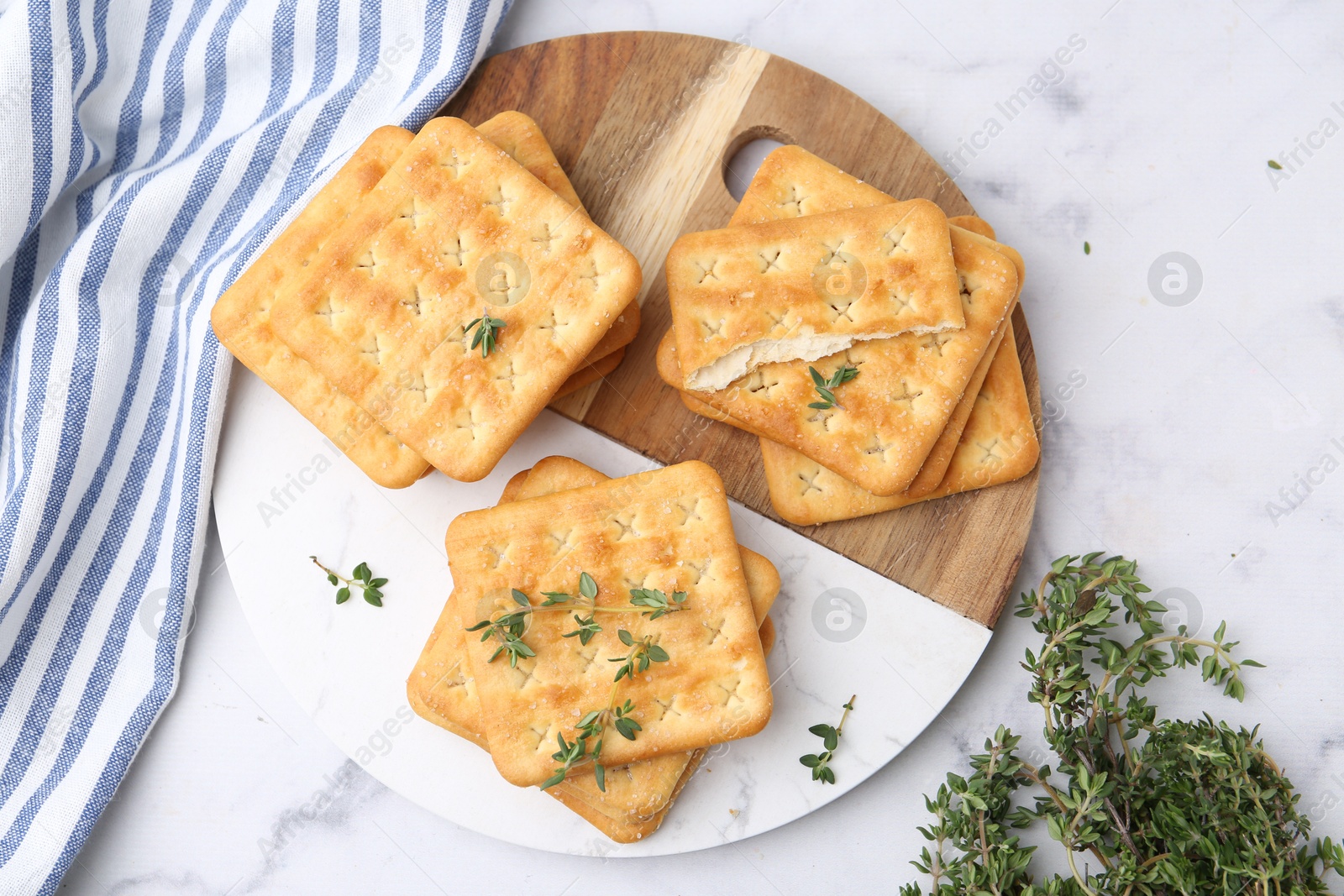 Tasty salty crackers with thyme on white marble table, top view Photo of Tasty salty crackers with thyme on white marble table, top view