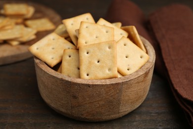 Photo of Tasty salty crackers on wooden table, closeup