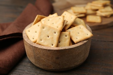 Photo of Tasty salty crackers on wooden table, closeup