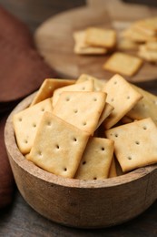 Photo of Tasty salty crackers on wooden table, closeup
