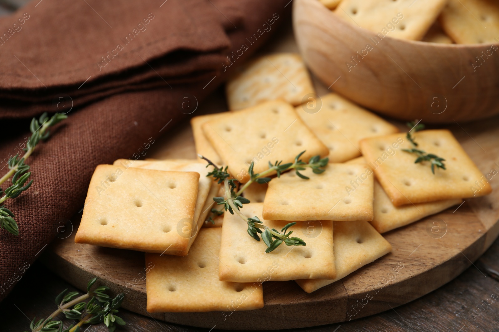 Tasty salty crackers with thyme on wooden table, closeup Photo of Tasty salty crackers with thyme on wooden table, closeup