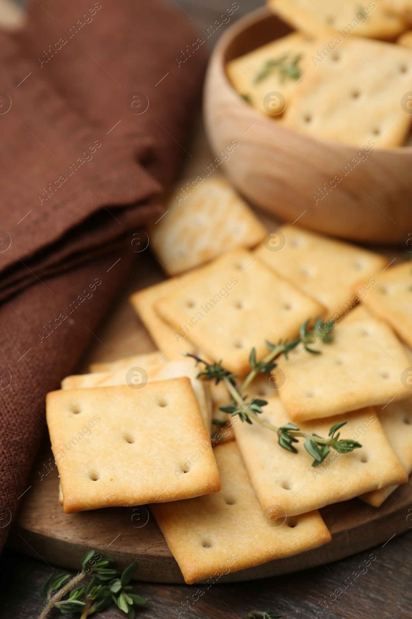 Tasty salty crackers with thyme on wooden table, closeup Photo of Tasty salty crackers with thyme on wooden table, closeup