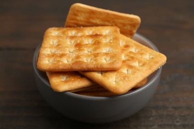 Photo of Tasty salty crackers on wooden table, closeup