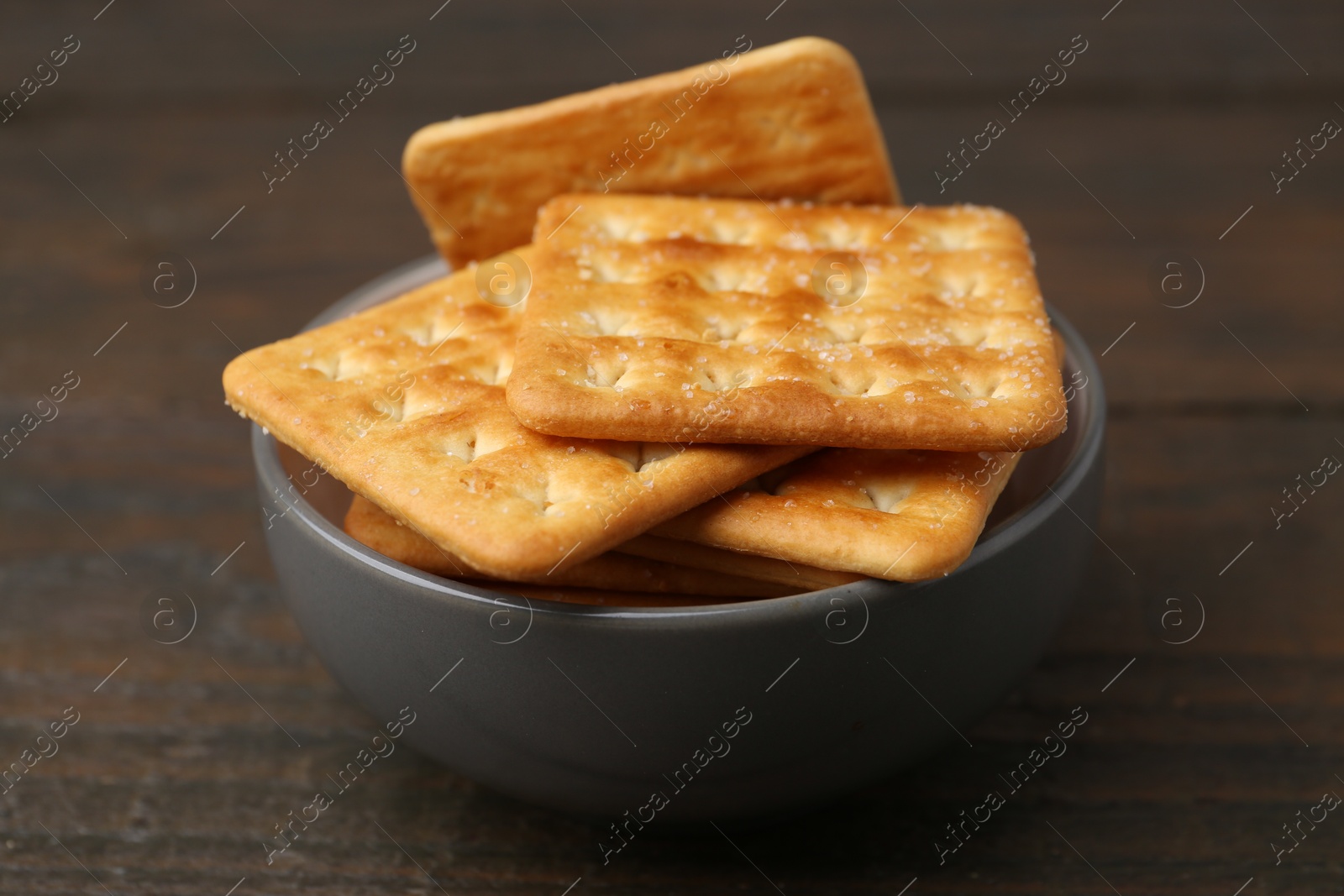 Tasty salty crackers on wooden table, closeup Photo of Tasty salty crackers on wooden table, closeup
