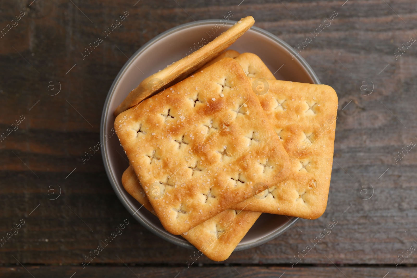 Tasty salty crackers on wooden table, top view Photo of Tasty salty crackers on wooden table, top view